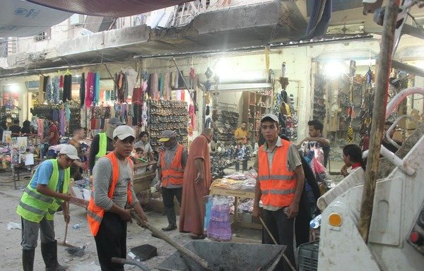 فريق تنظيف يزيل الحطام من جوانب شارع الأطباء في الرمادي مع إعادة فتح الأسواق أمام الأهالي. [سيف أحمد/ديارنا]