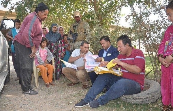 Les employés du gouvernement irakien recueillent les données des résidents d'al-Qayyarah pour les inclure dans un programme d'aide financière après que leur district a été libéré août dernier. [Photo fournie par le ministère irakien du travail et des affaires sociales]