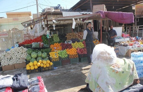 در یک بازارچه رنگارنگ در فلوجه میوه و سبزی فروخته می شود. [سیف احمد/ دیارنا]