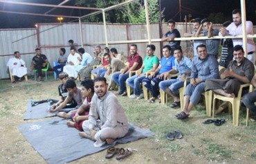 لاعبون ومتفرجون يستمتعون بلعبة المحيبس التقليدية خلال شهر رمضان حتى ساعات الصباح الأولى.