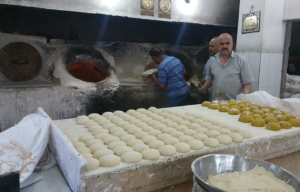 مخبز يقدم الخبز للصائمين بعد حلول الإفطار في شارع المصارف، وهو أحد أكثر الشوارع ازدحاماً في الفلوجة.