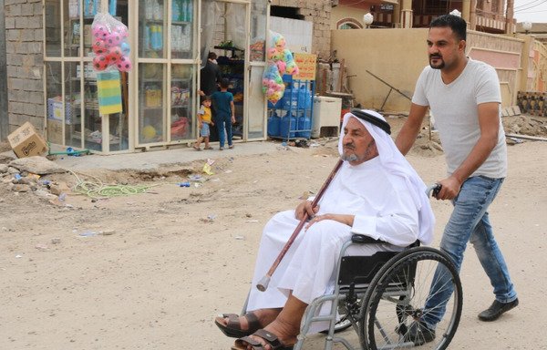 Un père et son fils originaires du quartier al-Joulan de Falloujah en route pour le bureau de vote. [Saif Ahmed/Diyaruna]