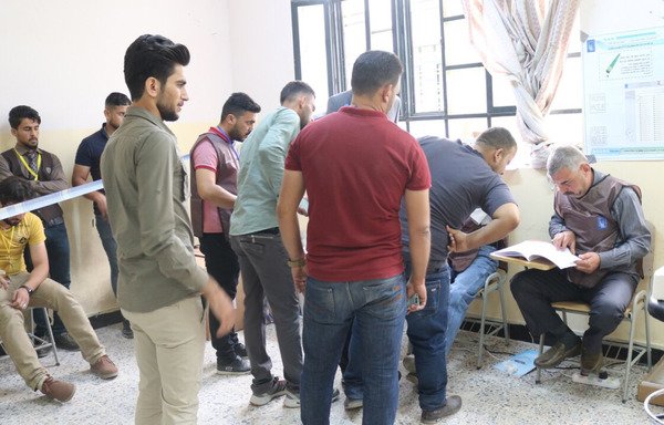 Au lycée al-Falloujah, des hommes de tous âges attendent pour mettre leur bulletin dans l'urne à l'occasion des élections législatives irakiennes. [Saif Ahmed/Diyaruna]