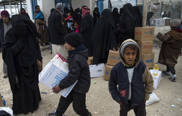 Des déplacés syriens reçoivent une aide humanitaire le 7 février dans le camp d'al-Hol de la province syrienne d'al-Hasakeh. [Fadel Senna/AFP]