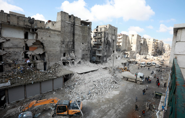 Le 11 février, des tracteurs et des camions déblaient les gravats du district de Salaheddine à Alep, qui était contrôlé par l'opposition. [Louai Beshara/AFP]