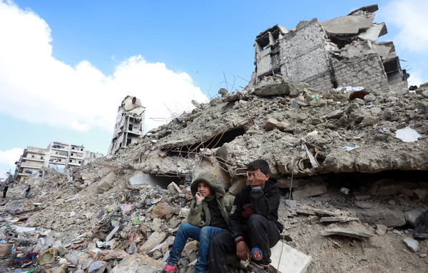 Des enfants dans les décombres de bâtiments lourdement endommagés ou détruits lors des batailles entre les combattants de l'opposition et les forces du régime dans le district de Salaheddine à Alep, le 11 février. [Louai Beshara/AFP] 