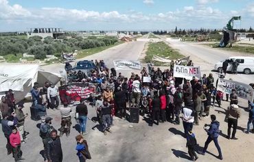 Des militants syriens manifestent sur l'autoroute M4 à Idlib