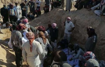 Les corps de membres de la tribu al-Shaitat exécutés par l'EIIS retirés d'un charnier