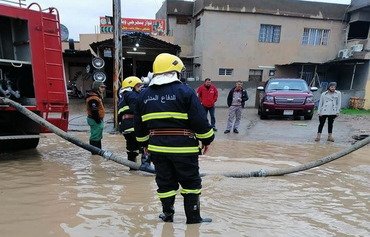 الدفاع المدني العراقي ينقذ عائلات حاصرتها السيول بالموصل