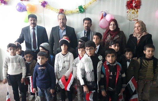 Teachers and students pose for a photograph at the official opening of a special needs classroom in Anbar in January. [Saif Ahmed/Diyaruna]