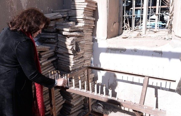 A member of the visiting Christian delegation lights a candle at the Church of St. Korkis in Anbar. [Photo courtesy of al-Shabab Radio station in Ramadi]