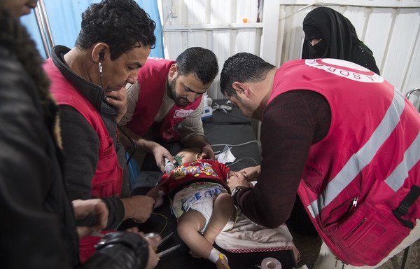 پزشکان و پرسنل درمانگاه موقتی اردوگاه آوارگان الهول در استان الحسکه روز 6 فوریه یک کودک را درمان می کنند. [فاضل سنا/خبرگزاری فرانسه]