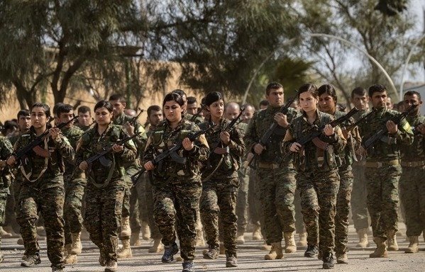 SDF fighters take part in a parade to celebrate near the Omar oil field in the eastern Syrian Deir Ezzor province on March 23rd, after announcing the total elimination of ISIS's last bastion in al-Baghouz. [Delil Souleiman/AFP]