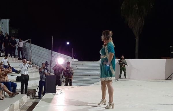 مصورون يلتقطون الصور أثناء قيام عارضة أزياء عراقية بعرض فستان إحدى المصممات المعروفات خلال عرض أزياء نظم في 18 آب/أغسطس في الأنبار. [سيف أحمد/ديارنا]