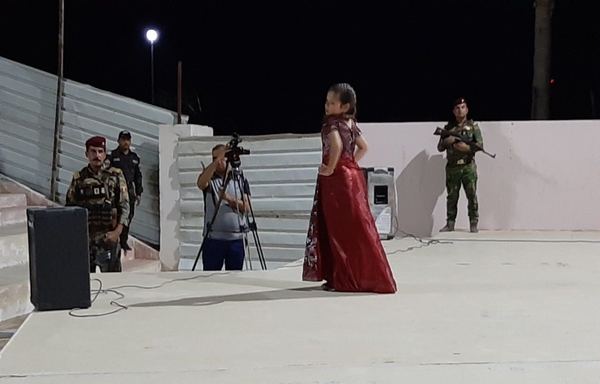 A child models a party dress during a fashion show in Anbar that featured clothing for all ages. [Saif Ahmed/Diyaruna]