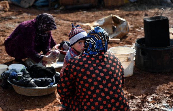 یک زن آواره شده درروز هفدهم فوریه در اردوگاه سرمده در استان ادلب بچه ای را دربغل دارد.[رامی السید/خبرگزاری فرانسه]