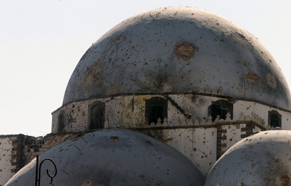 A photo taken July 31, 2013, shows the bullet-riddled dome of Khaled bin Walid mosque, whose mausoleum was partially destroyed during Syrian regime shelling in al-Khalidiyah district of Homs. [Joseph Eid/AFP]