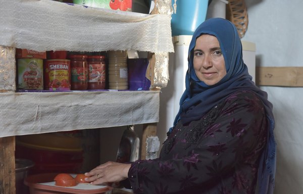 في مطبخها المتواضع، تحضر اللاجئة السورية عوفة علي الخضر إفطار رمضان الذي ضغت عليه هذا العام الحبوب والخضروات. [زياد حاتم/المشارق]