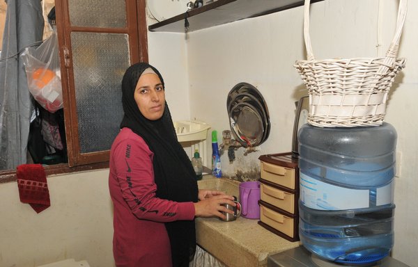 Laila Khalil has been working to help her husband provide their family with its basic needs. More than half of the money they bring in goes towards rent for the room where they live. [Ziad Hatem]