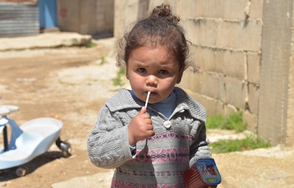 طفلة تشرب العصير في مخيم للنازحين بمدينة سعدنايل البقاعية في خريف العام 2021. [زياد حاتم]