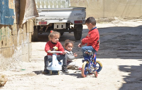 Syrian refugee children play in the street of a refugee camp in the Bekaa Valley, instead of being at school. [Ziad Hatem]