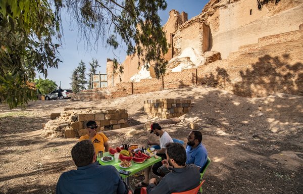 رجال يتشاركون وجبة طعام عند أطلال قلعة جعبر في خزان بحيرة الأسد في محافظة الرقة يوم 3 حزيران/يونيو. [دليل سليمان/وكالة الصحافة الفرنسية]