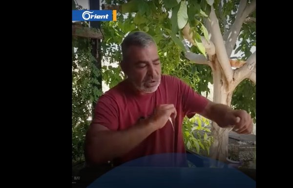 في لقطة شاشة من شريط فيديو بثت على موقع يوتيوب، يقوم المقاتل السابق في حزب الله حسن محمود محسن بتمزيق صور له مع زعيم الحزب حسن نصر الله.